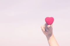 La donna ostacola un cuore rosso a disposizione fotografia stock La donna ostacola un cuore rosso a disposizione fotografia stock