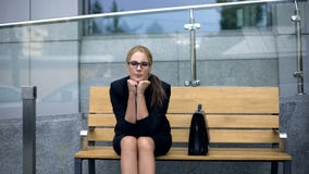 La donna sola turbata di affari che si siede sul banco, si è preoccupata per il licenziamento da lavoro fotografie stock libere da diritti La donna sola turbata di affari che si siede sul banco, si è preoccupata per il licenziamento da lavoro fotografie stock libere da diritti