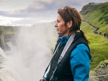La donna sta stando ad una cascata di Gullfoss - Islanda Immagini Stock Libere da Diritti La donna sta stando ad una cascata di Gullfoss - Islanda Immagini Stock Libere da Diritti