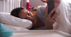 La donna svegliata dall'allarme sul telefono cellulare controlla i messaggi a letto video d archivio La donna svegliata dall'allarme sul telefono cellulare controlla i messaggi a letto video d archivio