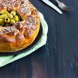 La empanada sabrosa, el pan de mono redondo con oives rellenos de los bollos y el queso, rematado con queso rallado y el cuenco n fotografía de archivo La empanada sabrosa, el pan de mono redondo con oives rellenos de los bollos y el queso, rematado con queso rallado y el cuenco n fotografía de archivo