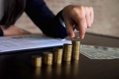 La empresaria escoge monedas en la tabla, cuenta el dinero Concepto del asunto fotos de archivo libres de regalías La empresaria escoge monedas en la tabla, cuenta el dinero Concepto del asunto fotos de archivo libres de regalías