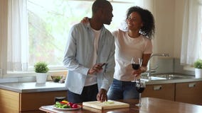 La familia africana feliz joven disfruta de risa del cocinero junta en cocina almacen de video La familia africana feliz joven disfruta de risa del cocinero junta en cocina almacen de video