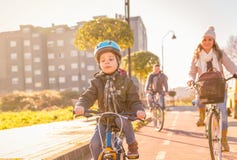 La familia con el montar a caballo del niño monta en bicicleta en la ciudad fotografía de archivo La familia con el montar a caballo del niño monta en bicicleta en la ciudad fotografía de archivo