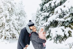 la familia joven feliz camina con el bebé en la calle del invierno, mamá, papá, c fotografía de archivo la familia joven feliz camina con el bebé en la calle del invierno, mamá, papá, c fotografía de archivo