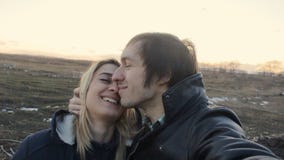 La familia joven hace el selfie en el campo y besa la cámara lenta almacen de metraje de vídeo La familia joven hace el selfie en el campo y besa la cámara lenta almacen de metraje de vídeo