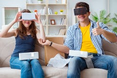 La familia joven que juega a juegos con los vidrios de la realidad virtual fotografía de archivo La familia joven que juega a juegos con los vidrios de la realidad virtual fotografía de archivo