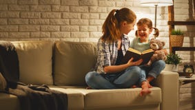 La famille avant mère allante au lit lit au livre n de fille d'enfant photo stock La famille avant mère allante au lit lit au livre n de fille d'enfant photo stock