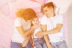 La famille heureuse dans le lit, la maman, le fils et le papa sont embrassants et ?treignants ensemble images stock La famille heureuse dans le lit, la maman, le fils et le papa sont embrassants et ?treignants ensemble images stock