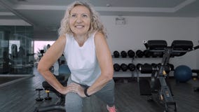 La femme ag?e fait des squattings dans le gymnase La femme supérieure de femme agée fait des exercices d'un sport dans le gymnase image stock La femme ag?e fait des squattings dans le gymnase La femme supérieure de femme agée fait des exercices d'un sport dans le gymnase image stock