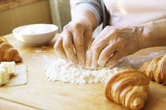 La femme agée fait cuire les croissants français, découvrent les mains froissées, ingrédients, lumière chaude molle de matin, vue Images libres de droits La femme agée fait cuire les croissants français, découvrent les mains froissées, ingrédients, lumière chaude molle de matin, vue Images libres de droits