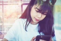 La femme asiatique dans un café touche l'écran de smartphone, utilisant envoient un message à une application sociale de media d' image libre de droits La femme asiatique dans un café touche l'écran de smartphone, utilisant envoient un message à une application sociale de media d' image libre de droits