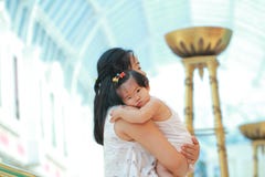 La femme chinoise étreignent son bébé sur des bras Photographie stock La femme chinoise étreignent son bébé sur des bras Photographie stock