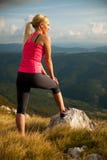 La femme de coureur se repose sur un dessus de montagne après séance d'entraînement courante image stock La femme de coureur se repose sur un dessus de montagne après séance d'entraînement courante image stock