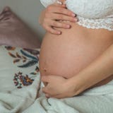 La femme enceinte attirante s'assied dans le lit et tient son ventre Derniers mois de grossesse images stock La femme enceinte attirante s'assied dans le lit et tient son ventre Derniers mois de grossesse images stock