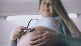 la femme enceinte utilise un stéthoscope pour écouter le cœur du bébé.  écouter les voix de