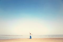 La femme fait des exercices de méditation faisant face à la mer photographie stock libre de droits La femme fait des exercices de méditation faisant face à la mer photographie stock libre de droits