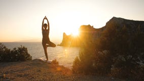 La femme font le yoga au coucher du soleil La femme font le yoga au coucher du soleil