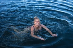 La femme heureuse nage dans le lac bleu photographie stock La femme heureuse nage dans le lac bleu photographie stock