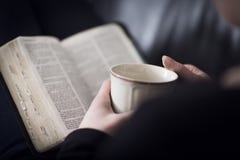 La femme a lu la bible et boit du thé ou du café