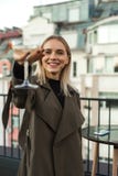 La femme positive gaie tient le verre de tige photographie stock La femme positive gaie tient le verre de tige photographie stock