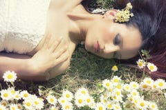 La femme se trouvant sur une herbe fleurit Yeux fermés horizontal image libre de droits La femme se trouvant sur une herbe fleurit Yeux fermés horizontal image libre de droits