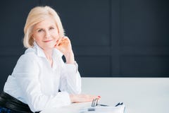 La femme supérieure satisfaite a détendu le temps de repos exécutif image stock La femme supérieure satisfaite a détendu le temps de repos exécutif image stock