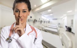 La femme sérieuse de docteur faisant le silence signent plus de le couloir d'hôpital photos libres de droits La femme sérieuse de docteur faisant le silence signent plus de le couloir d'hôpital photos libres de droits