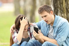 La femme triste montre le message à un ami étonné photographie stock libre de droits La femme triste montre le message à un ami étonné photographie stock libre de droits