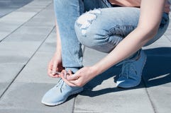 La fille attache des dentelles sur des espadrilles photo libre de droits La fille attache des dentelles sur des espadrilles photo libre de droits