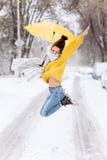 La fille aux cheveux foncés heureuse habillée dans un chandail jaune, des jeans et une écharpe blanche saute avec un parapluie ja photos stock La fille aux cheveux foncés heureuse habillée dans un chandail jaune, des jeans et une écharpe blanche saute avec un parapluie ja photos stock