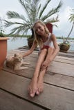 La fille de touristes caresse le chat de gingembre au pilier en Koh Panyee photo libre de droits La fille de touristes caresse le chat de gingembre au pilier en Koh Panyee photo libre de droits