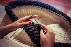 La fille faisant un souffle de crochet avec la laine et les clous blancs et gris a peint rouge photos stock La fille faisant un souffle de crochet avec la laine et les clous blancs et gris a peint rouge photos stock