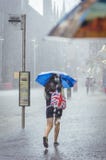 La fille marche à la pluie d'été dans la ville photos libres de droits La fille marche à la pluie d'été dans la ville photos libres de droits