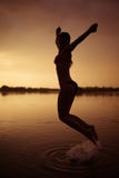 La fille sautent en rivière au coucher du soleil image stock La fille sautent en rivière au coucher du soleil image stock