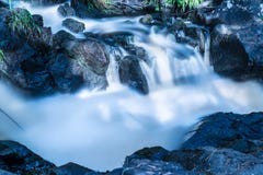 La foto de la pequeña cascada o catarata en el bosque taked en el día de verano soleado caliente con la exposición larga imagen de archivo libre de regalías La foto de la pequeña cascada o catarata en el bosque taked en el día de verano soleado caliente con la exposición larga imagen de archivo libre de regalías