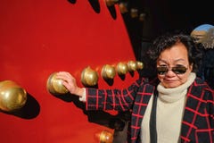 La foto del ritratto delle donne asiatiche senior prende il portone severo del palazzo a Pechino immagine stock libera da diritti La foto del ritratto delle donne asiatiche senior prende il portone severo del palazzo a Pechino immagine stock libera da diritti