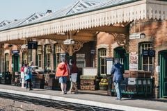 La gente che cammina su un retro binario del treno della stazione ferroviaria di Sheringham, Norfolk, Regno Unito fotografia stock libera da diritti La gente che cammina su un retro binario del treno della stazione ferroviaria di Sheringham, Norfolk, Regno Unito fotografia stock libera da diritti