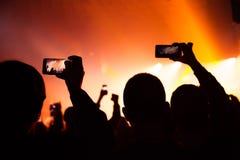 La gente che guarda un concerto e qualcuno foto e video della fucilazione con un cellulare fotografia stock libera da diritti La gente che guarda un concerto e qualcuno foto e video della fucilazione con un cellulare fotografia stock libera da diritti