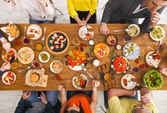 La gente come comidas sanas en el partido de cena servido de la tabla imagen de archivo libre de regalías La gente come comidas sanas en el partido de cena servido de la tabla imagen de archivo libre de regalías