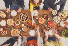 La gente come comidas sanas y tintinea los vidrios en el partido de cena servido de la tabla fotos de archivo La gente come comidas sanas y tintinea los vidrios en el partido de cena servido de la tabla fotos de archivo