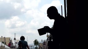La gente pasa por las limosnas que buscan de un viejo mendigo masculino ciego en el portal de la iglesia almacen de video La gente pasa por las limosnas que buscan de un viejo mendigo masculino ciego en el portal de la iglesia almacen de video