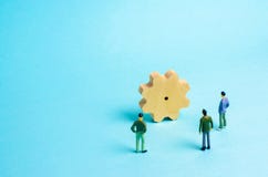 La gente sta stando intorno ad un ingranaggio enorme e sta studiandolo Concetto delle idee, degli investimenti e della cooperazio fotografia stock libera da diritti La gente sta stando intorno ad un ingranaggio enorme e sta studiandolo Concetto delle idee, degli investimenti e della cooperazio fotografia stock libera da diritti