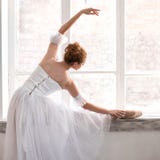 La giovane ballerina sta allungando sul corridoio di ballo immagini stock La giovane ballerina sta allungando sul corridoio di ballo immagini stock