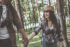 La giovane coppia positiva nell'amore sta camminando in foresta immagini stock libere da diritti La giovane coppia positiva nell'amore sta camminando in foresta immagini stock libere da diritti