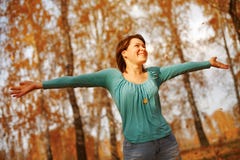 La giovane donna arma alzato godendo dell'aria fresca nella foresta di autunno fotografie stock libere da diritti La giovane donna arma alzato godendo dell'aria fresca nella foresta di autunno fotografie stock libere da diritti