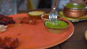 La giovane donna e la sua famiglia mangiano l'alimento indiano in caffè archivi video La giovane donna e la sua famiglia mangiano l'alimento indiano in caffè archivi video