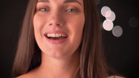 La giovane donna solleva le sue sopracciglia, morde le sue labbra, flirtanti con la macchina fotografica sul fondo delle blured-l video d archivio La giovane donna solleva le sue sopracciglia, morde le sue labbra, flirtanti con la macchina fotografica sul fondo delle blured-l video d archivio