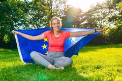La giovane donna sta indossando una bandiera europea dietro ed i sorrisi fotografia stock La giovane donna sta indossando una bandiera europea dietro ed i sorrisi fotografia stock