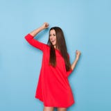 La giovane donna sta ridendo con le armi alzate Fotografia Stock La giovane donna sta ridendo con le armi alzate Fotografia Stock